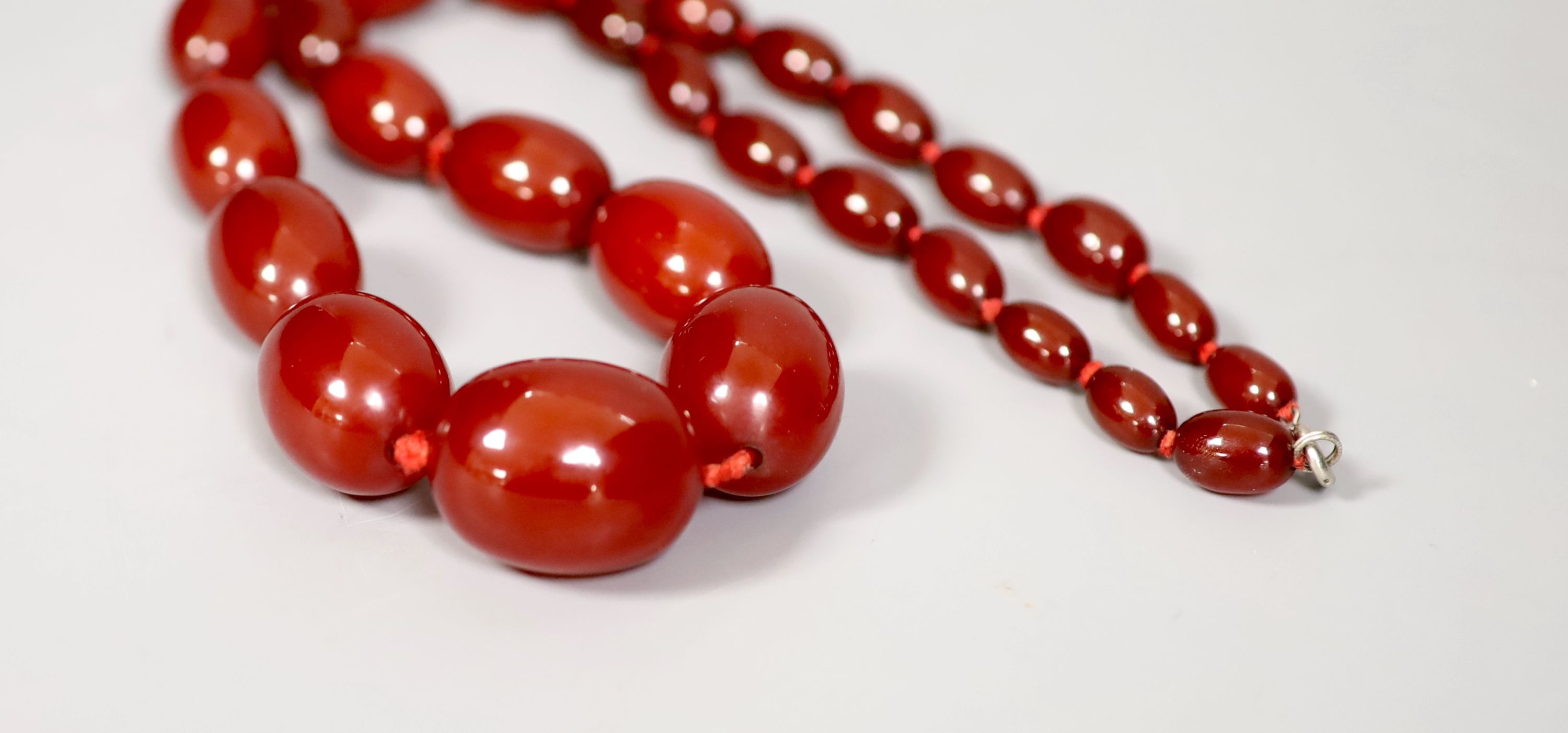A single strand graduated simulated cherry amber necklace, 60cm, gross 69 grams.
